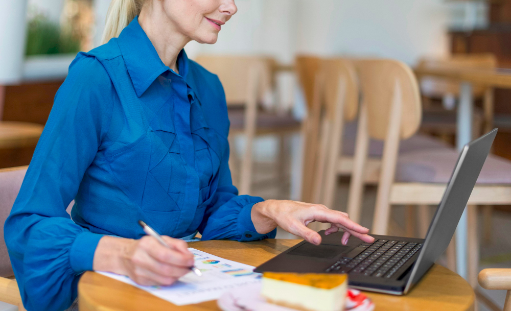 side-view-older-business-woman-working-laptop-with-papers